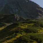 Scenic view of lush green hills and towering mountains in Tatra National Park, Poland.